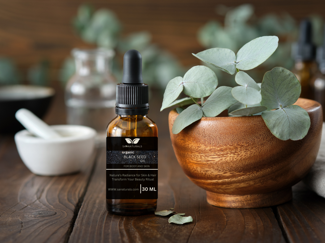 SA Naturals Black Seed Oil 30ml bottle on wooden table beside green herbs and wellness tools, highlighting purity and organic skincare benefits.